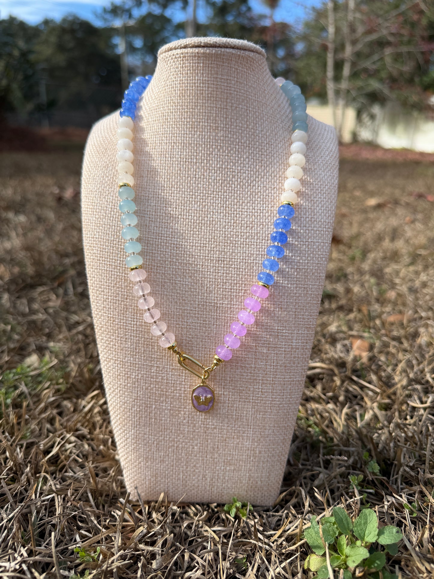 Colorful beaded necklace on a mannequin bust with a natural background